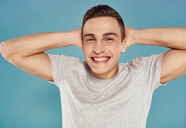 Neşeli yakışıklı adam beyaz tişört yakın plan duyguları mavi arka plan