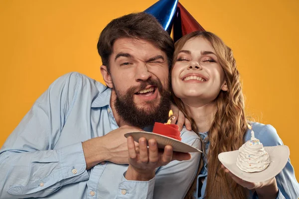 Narozeniny party muž a žena zábava žluté pozadí čepice dovolená — Stock fotografie