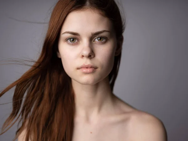Porträtt av en vacker kvinna närbild rött hår grå bakgrund Läge — Stockfoto