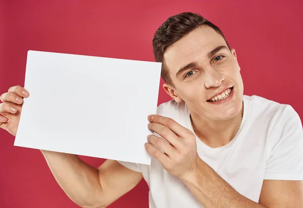 Un homme fait des gestes avec ses mains et une feuille blanche de prospectus publicitaire en papier — Photo