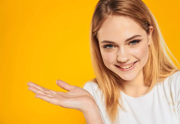 Feliz mulher loira gesticulando com as mãos em um fundo amarelo Copiar Espaço — Fotografia de Stock