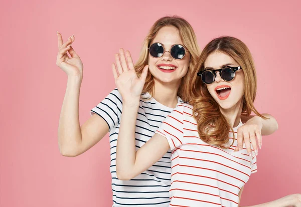 Két érett nő visel napszemüveg kommunikáció barátság érzelmek öröm rózsaszín háttér — Stock Fotó