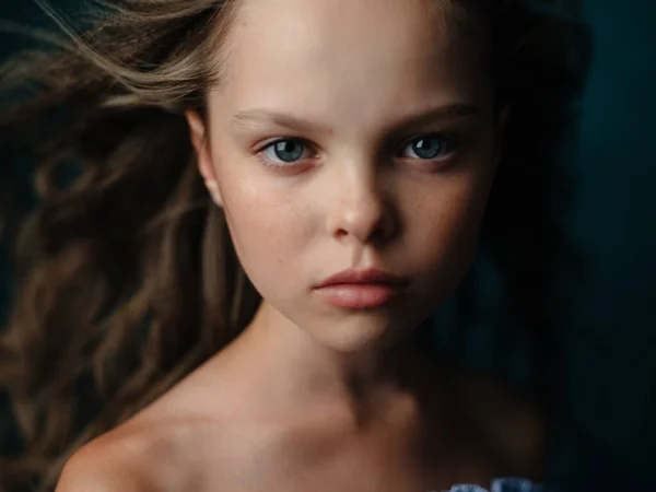Rozkošné krásné dítě dívka na tmavém pozadí close-up portrét oříznutý pohled — Stock fotografie