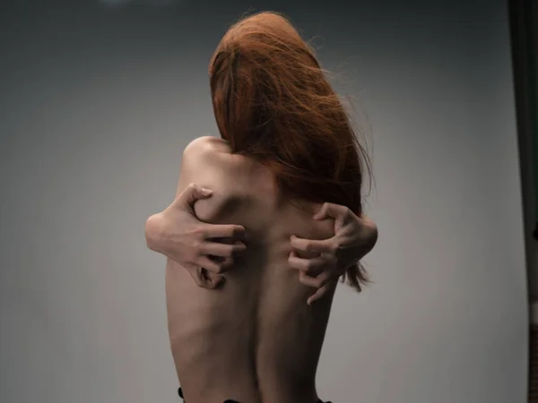 Тонка жінка торкається себе за спиною руками з емоційною моделлю — стокове фото