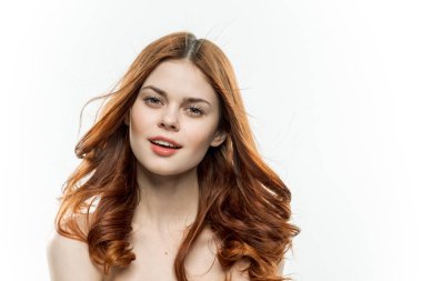 Çıplak omuzlu, kızıl saçlı çekici bir kadın.