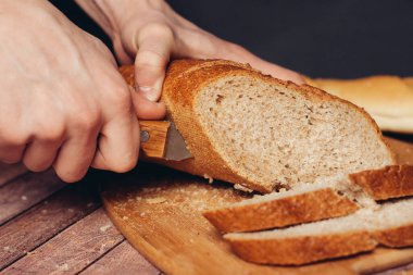 Dilimlenmiş taze somun, tahta kesme masası.