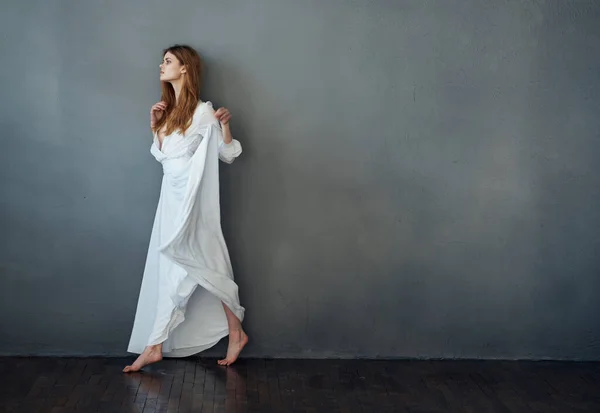 魅力的な女性の白いドレス豪華なパフォーマンススタジオグレーの背景 — ストック写真