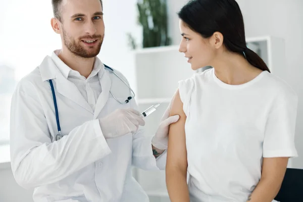 Profesyonel doktor, kadın hastaların omzuna aşı enjekte ediyor. — Stok fotoğraf