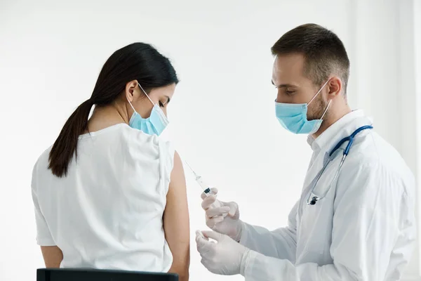 Лікар в медичній масці ін'єкційна вакцина проти епідемії жінок плеча — стокове фото