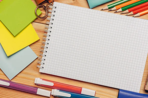 Notebook színes papír írószer közelkép íróasztal felülnézet — Stock Fotó