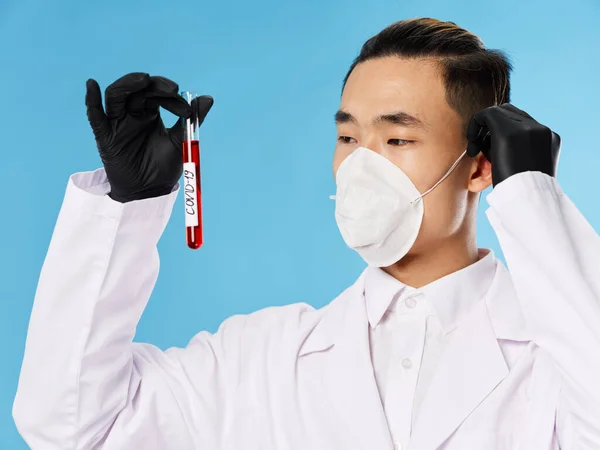 Man aziatische verschijning laboratorium onderzoek diagnostiek zwart handschoen blauw achtergrond — Stockfoto