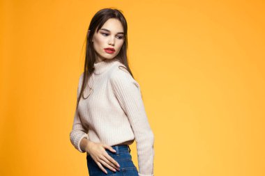 Sevimli esmer makyaj kırmızı dudaklar moda kıyafetler sarı arka plan