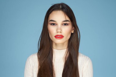Güzel kadın kırmızı dudaklı beyaz ceketli çekici yakın plan mavi arka plan