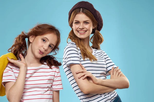 Hermanas de moda en sombreros divertido estilo de vida estudio de fondo azul —  Fotos de Stock