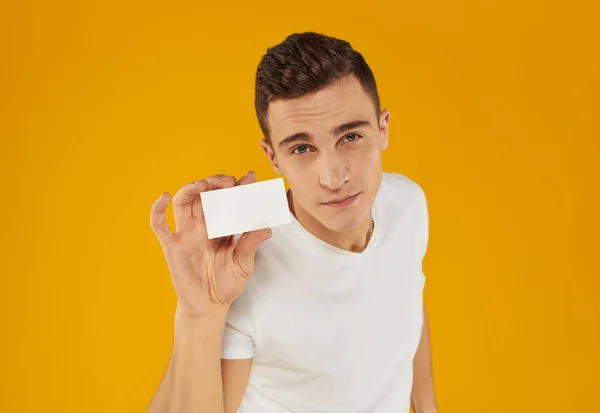 Hombre con tarjeta blanca sobre fondo amarillo Copiar Espacio maqueta — Foto de Stock