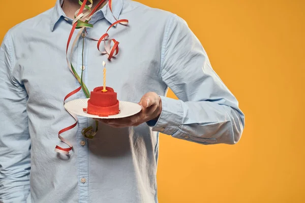 Cumpleaños niño en una gorra con un pastel de cumpleaños en la mano y una vela — Foto de Stock