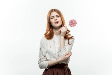 Ellerinde lolipopları olan kızıl saçlı güzel bir kadın. 
