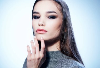 Gri kazak ve göz farı takmış güzel bir esmerin portresi, akşam makyajı.