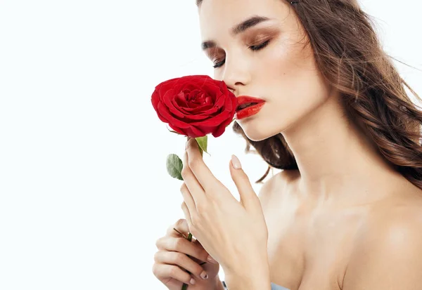 Charmante femme brune aux épaules nues et à la fleur parfumée près de son visage — Photo