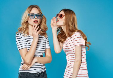 İki kadın modaya uygun kıyafetler. Koyu gözlükler. İletişim.