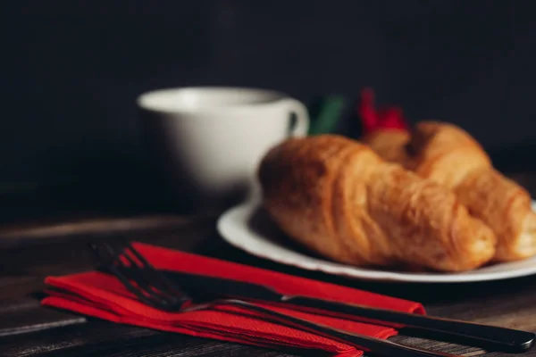 Knusprige Croissants auf einem Teller Holztisch Kaffeebecher — Stockfoto
