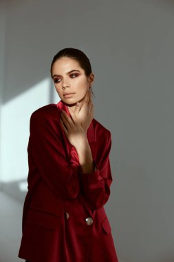 Esmer, moda kıyafetleri, eller yüz aydınlatıcı arka planda.