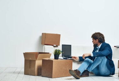 İş adamı kutularında dizüstü bilgisayar var. Profesyonel eşyaların paketlerini açıyor.