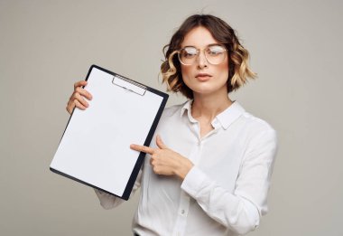 Tişörtlü, gözlüklü bir iş kadını ve elinde beyaz bir maket kağıtla büyükannesi.