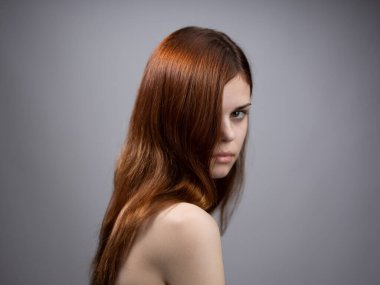 Gri arka planda kızıl saçlı güzel bir kadın omuzlarında çıplak bir portre vardı.