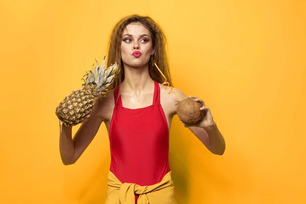 Mulher com abacaxi e coco coquetel frutas exóticas verão estilo de vida fundo amarelo — Fotografia de Stock