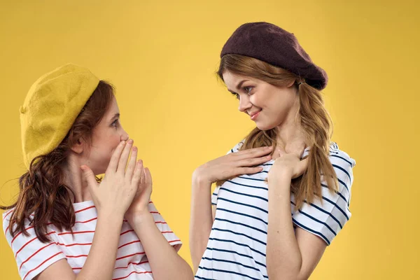 Χαρούμενες αδελφές με καπέλα ριγέ T-shirts χαρά τρόπο ζωής κίτρινο φόντο οικογένεια — Φωτογραφία Αρχείου