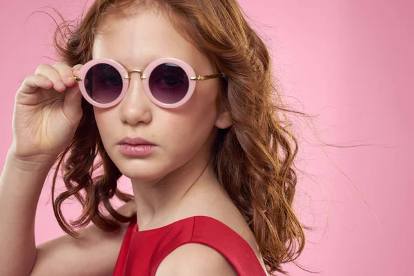 Menina com cabelo encaracolado escuro redondo óculos divertido vestido vermelho fundo rosa — Fotografia de Stock