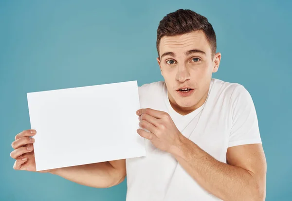 Cute man with white sheet of paper on blue background cropped view mockup