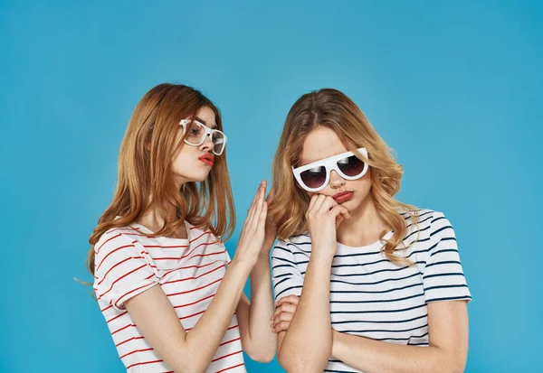 티셔츠를 입고 즐거운 의사소통을 하는 두 여성의 배경은 푸른 색이다 — 스톡 사진