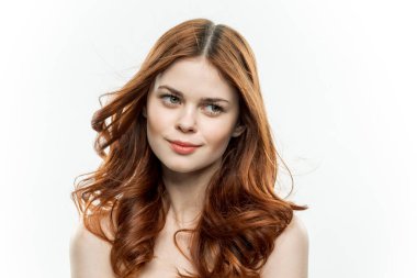 Neşeli kadın çekici görünüyor. Çıplak omuzlar. Açık renk arka plan.