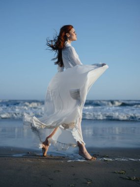 Sahilde, okyanusun kenarında, tamamen büyümüş bir kadının portresi.