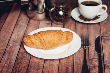 Kahvaltı masasındaki tabakta taze kruvasan.