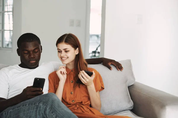 Man and woman at home on the couch with phones in their hands communication — Photo