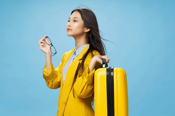 여행 가방을 들고 푸른 배경으로 여행하는 아시아 출신의 여자 — 스톡 사진