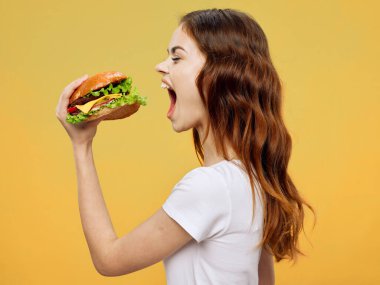woman with open mouth holding hamburger in hand fast food diet food