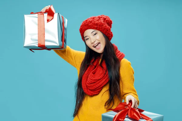 Vidám nő piros kalapban egy ajándék a kezében ünnep karácsonyi stúdió — Stock Fotó