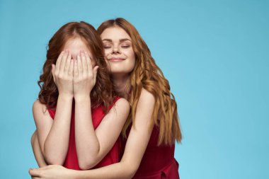 Kırmızı elbiseli anne ve kız eğlence hayatı tarzı stüdyo mavisi arka plan