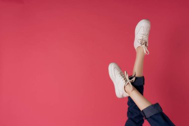 Beyaz spor ayakkabılar ters bacaklar hareket sokak moda pembe arka plan