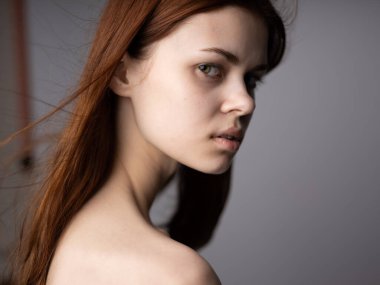 Gri arka plan için omuzları açık bir kadın portresi