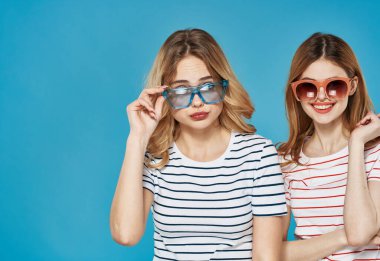 İki kadın modaya uygun kıyafetler. Koyu gözlükler. İletişim.