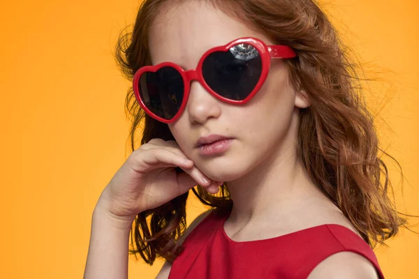 Alegre linda chica gafas en forma de un corazón de la moda de cerca de fondo amarillo —  Fotos de Stock