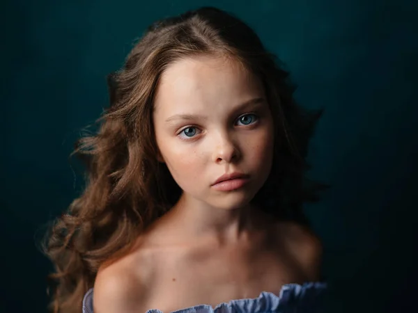 Retrato de una hermosa niña en un vestido de sol sobre un fondo oscuro de cerca — Foto de Stock