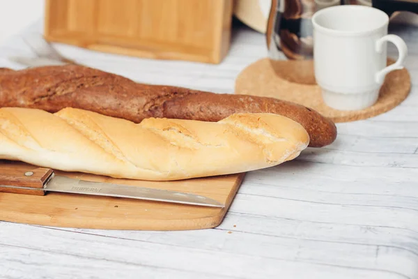 Chleb na drewnianym stole kuchenny nóż do pieczenia — Zdjęcie stockowe