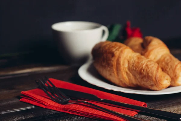 Croissanter på tallrik en kopp kaffe träbord dessert — Stockfoto