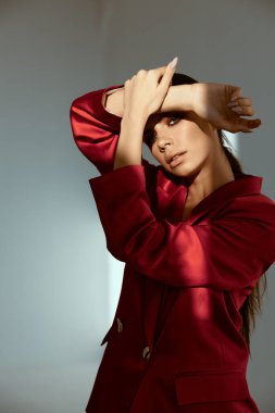 Kırmızı ceketli kadın yüzünde parlak bir makyajla